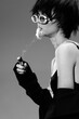 © SHOTPRIME STUDIO - Black and white portrait of a stylish woman smoking with round sunglasses and short hair in monochrome tone
