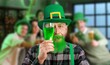 © Pixel-Shot - Funny mature man with glass of beer celebrating St. Patrick's Day in pub