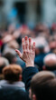 © Curioso.Photography - Raised hand of an audience member during a conference or public discussion event.