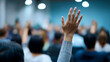 © Curioso.Photography - Audience members raising hands during a conference or seminar, representing participation and engagement.