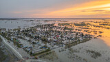 Aerial drone footage of a massive city flood with houses and streets submerged under water. Urban flooding caused by extreme weather and heavy rainfall, showing natural disaster impact on residential 
