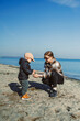 © DSMT - Mother and child playing on beach during sunny day near water
