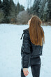 © DSMT - Girl walking in snowy field looking up at trees near forest during winter season in daylight