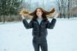 © DSMT - Woman with long hair poses in snowy field during winter while playing with her hair in a landscape with trees and cold weather