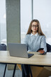 © DSMT - Woman works at desk with laptop and phone in modern office during afternoon