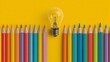 © sablengjago - A vibrant image with a row of colored pencils on a yellow background with a lightbulb above