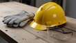 © photoplotnikov - Construction safety equipment: yellow hard hat, protective gloves, safety glasses on wooden table