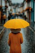 © Georgii - Woman With a Yellow Umbrella Walking in the Rain on a Cozy Urban Street