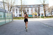 © Koldo_Studio - Fit woman running outdoors on a city sidewalk, focusing on healthy lifestyle and exercise. Back view of active female