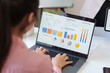 © PRIME STOCK LAB - Female professional analyzing business data and financial charts on a laptop screen while working in a modern office environment.
