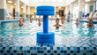 © Iryna - Blue foam resistance dumbbell on wet mosaic border in aquatic center, water aerobics and fitness training