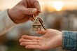 © vetrana - New homeowner receives house keys during sunset in a city setting with family or friends nearby celebrating the moment