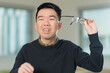 © fotolite - A Chinese student squints and holds his eyeglasses away from his face with difficulty seeing clearly, ideal for vision problems, nearsightedness, or eye care concepts.
