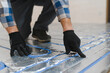 © Serhii - Service man instelling house heating system under the floor