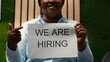 © DC Studio - African american female HR manager showing recruiting signs on papers to create a talent acquisition, announcing job vacancy and inviting skilled people to join the company workforce.