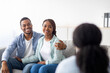 © Prostock-studio - Happy married couple after successful psychotherapy at marital counselor's office. Positive young black spouses sharing results with their psychologist, hugging on couch at clinic