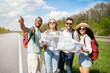 © Prostock-studio - Group of multiethnic friends checking map, choosing route during road trip, hitchhiking on highway. Autostop journey, summer holidays, wanderlust, freedom and friendship concept