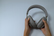© kawa_xxx - Close up of hands holding wireless headphones on white background