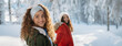 © Halfpoint - Two female friends walking in winter forest during holidays