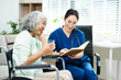 © Nuttapong punna - Asian nurse consulting elderly woman in wheelchair at home. Senior care, home healthcare, nursing support, communication and caregiver concept