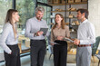 © ty - Four business people discussing work together using a tablet in a modern office