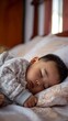 © Valentyna Prudnikova - Peaceful infant sleeping soundly on soft bedding, wrapped in cozy patterned blanket with gentle afternoon light filtering through window