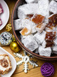 © soleg - Large bowl of traditional Turkish delight cubes covered in sugar powder with festive Christmas ornaments on a wooden table