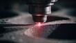 © khumthong - Close up of a laser cutting head precisely engraving a textured dark surface with a bright red beam