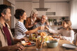 © Jelena - Multi-generational family celebrating together at home lunch