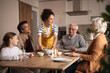 © Jelena - Woman serving family lunch at home kitchen table