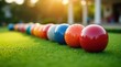 © Alex Pios - Close-up of colorfully designed lawn bowls on a green outdoor bowling green in bright sunlight
