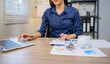 © Laingzaifa - Asian business professionals analyze accounts and documents, calculate budgets, expenses, loans, mortgages, insurance, real estate investments, and manage income, taxes, and residential strategies