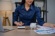 © Laingzaifa - Asian business professionals analyze accounts and documents, calculate budgets, expenses, loans, mortgages, insurance, real estate investments, and manage income, taxes, and residential strategies