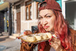 © EdNurg - Young woman looking with a face of disgust while holding a plate of traditional sweets on a city street
