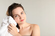 © New Africa - Beautiful woman drying hair with towel on light grey background. Space for text