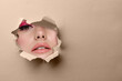 © New Africa - Young woman with beautiful makeup, closeup. View on face through torn hole in greige paper