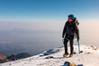 © ADDICTIVE STOCK - Alpinist on snowy summit of a volcano in safety gear