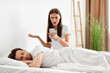 © Prostock-studio - Infidelity. Shocked Woman Reading Cheating Husband's Messages On Cellphone While He Sleeping, Catching Him On Affair With Lover In Bedroom At Home. Jealousy And Unfaithfulness. Selective Focus