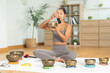 © Leny Studio - Tibetan singing bowl sound healing, Asian woman meditating at home yoga session, bronze instrument and mallet on cushion, calm breath practice, mindfulness wellness, zen harmony, serene peaceful