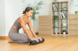 © Leny Studio - Candid asian female doing indoor yoga exercise on mat in minimal living room, wooden floor with plant shelf, soft light, relaxed breathing balanced posture peaceful healthy lifestyle mindful wellness