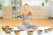 © Leny Studio - Tibetan singing bowl used for meditation by asian woman at home, sound healing session with bronze bowl and mallet, vibration resonance, calmness breath practice, mindfulness wellness, spiritual zen