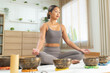 © Leny Studio - Tibetan singing bowl meditation ritual, Asian woman at home focuses on mindful breathing sound healing and relaxation supporting mental health inner peace emotional balance and a quiet tranquil moment