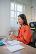 © Laingzaifa - The call center employee, with a cheerful smile and wearing headphones at their desk, communicates with customers, providing professional insurance support, sales, advice, and customer service.