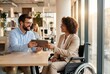 © Meow Creations - Man and woman in wheelchair collaborating on tablet in modern office