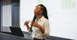 © Flash25/peopleimages.com - Presentation, public speaking or black woman with laptop at podium, company stats or performance data review. Business seminar, pc or worker with info analysis, charts or graphs for growth discussion