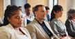 © Flash25/peopleimages.com - Business people, audience and listening in seminar, workshop or presentation for career development. Conference, group or crowd at tradeshow for advice, knowledge or feedback for professional growth.