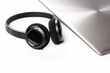 © Evgenii - Stylish wireless headphones lying next to closed laptop on minimalist background. Modern work style.