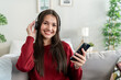 © Kawee - Portrait of Mixed race woman listen to music while sitting on sofa house.