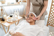 © Kawee - Beautiful woman getting facial massage with gua sha at beauty spa.