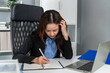 © Kawee - Frustrated Asian young businesswoman overwork late in office workplace.